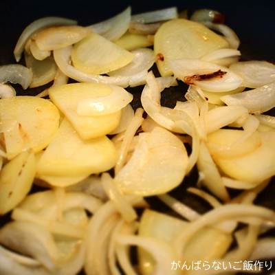 玉ねぎとジャガイモをフライパンで炒めている調理中の一コマ