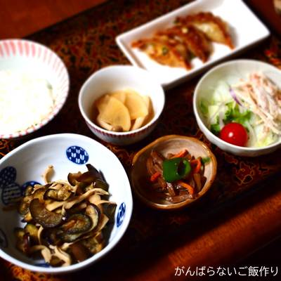なす・エリンギ・玉ねぎの中華炒めを使った献立。白ご飯、揚げ餃子、煮物、サラダの組み合わせ。