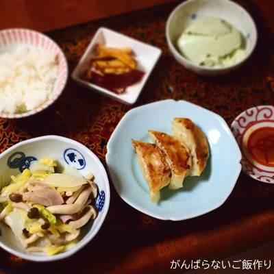 白菜・しめじの生ハム炒めを主菜にした夕食の献立。ご飯や餃子、大学いも、おぼろ豆腐を添えている