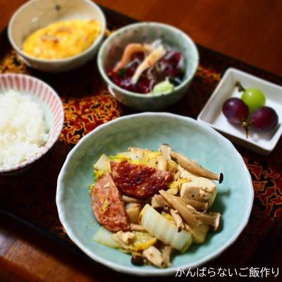 チーズリオナソーセージと白菜の煮物の献立。白ご飯、かに玉、海藻サラダ、ぶどうの組み合わせ。