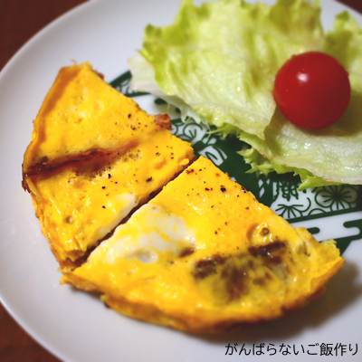 チーズリオナソーセージ入りオムレツ。レタスとミニトマトが添えられている一皿。